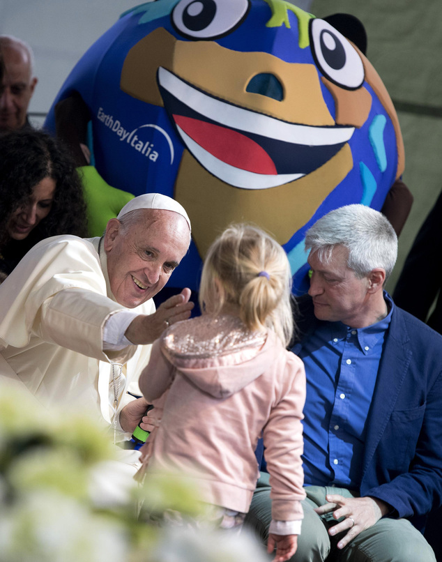 Pope Francis reaches out to caress a young girl during his appearance at an Earth Day event in Rome, Sunday, April 24, 2016. Francis made a surprise appearance at the Earth Day event getting up on stage to give an unscheduled address to the delight of the audience in the Villa Borghese park. (Claudio Peri/ANSA via AP) ITALY OUT